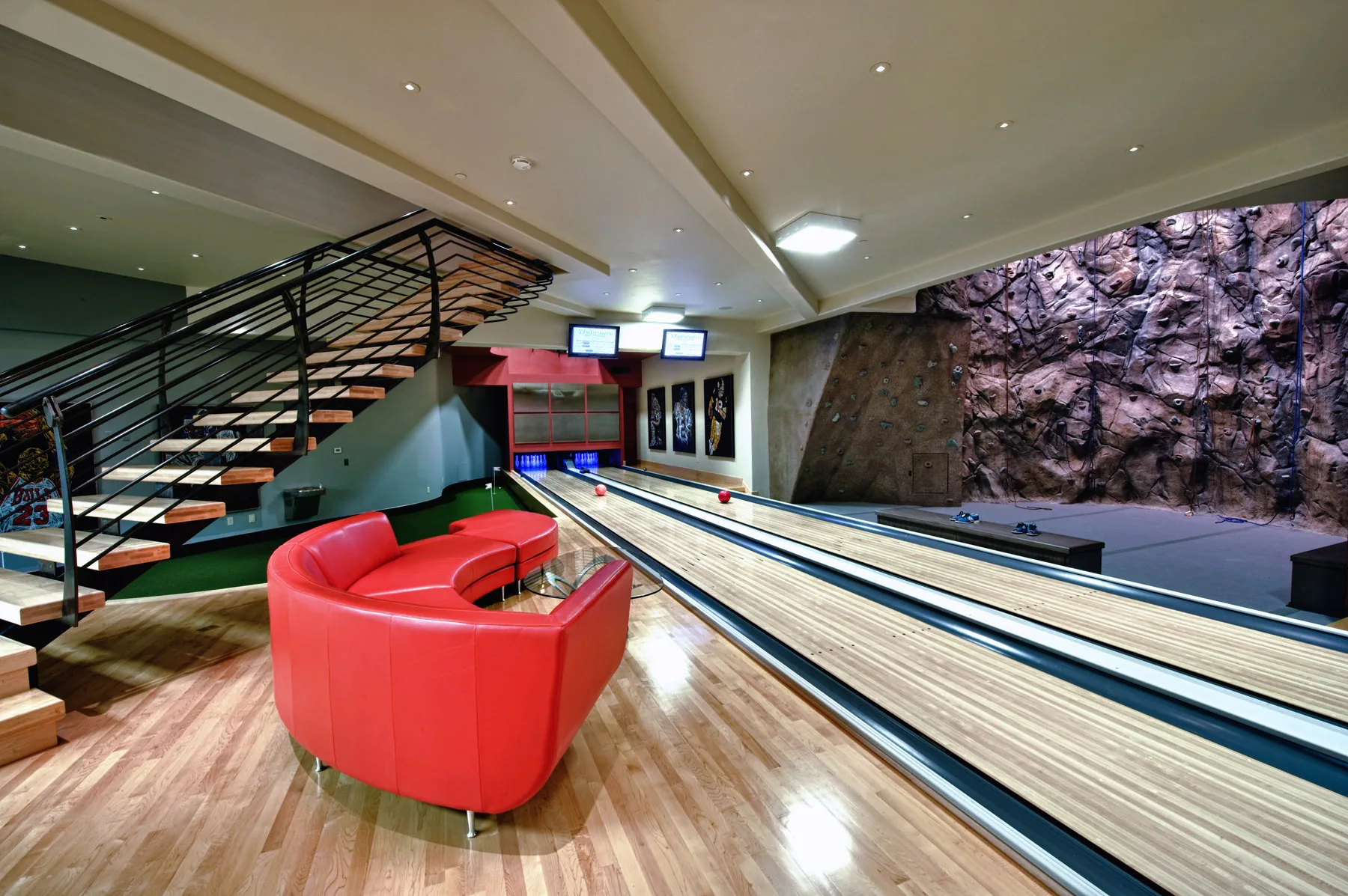 Private bowling alley carved into a rock wall with colorful striped lanes