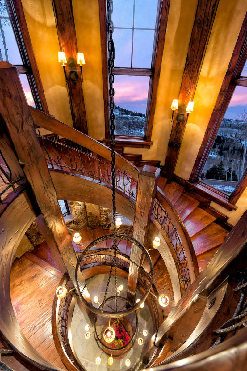Spiral staircase viewed from above with a round cluster pendant light fixture at its center