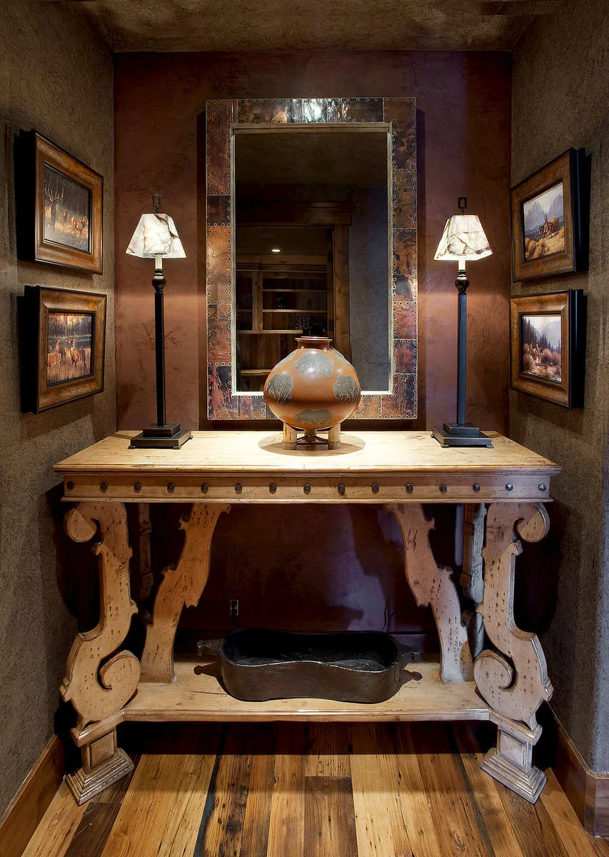 Foyer with a console table, mirror, table lamps and framed art