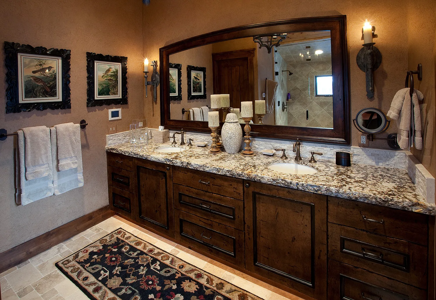 Bathroom with a dark wood vanity, granite counter and large mirror