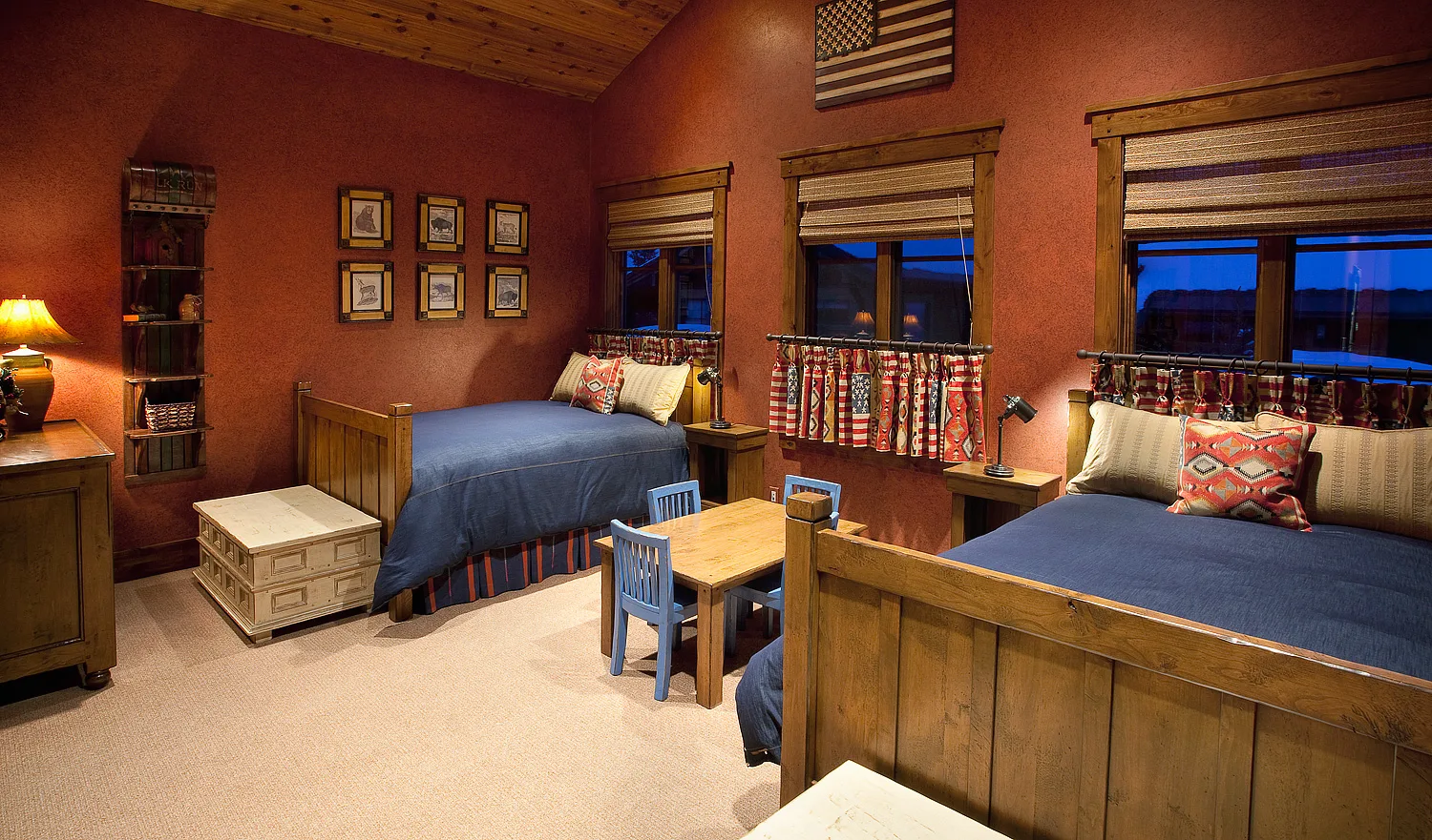 Bedroom with patriotic flag-themed decor and built-in bunk-style beds beside windows