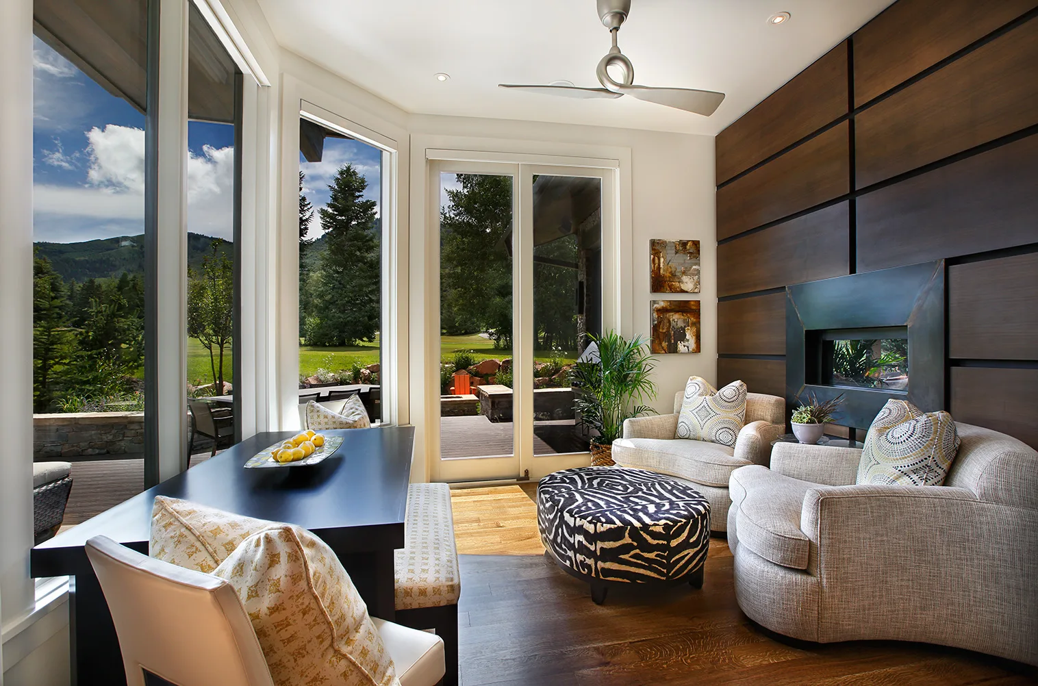 Sunroom breakfast nook with wicker furniture and floor-to-ceiling windows overlooking a golf course