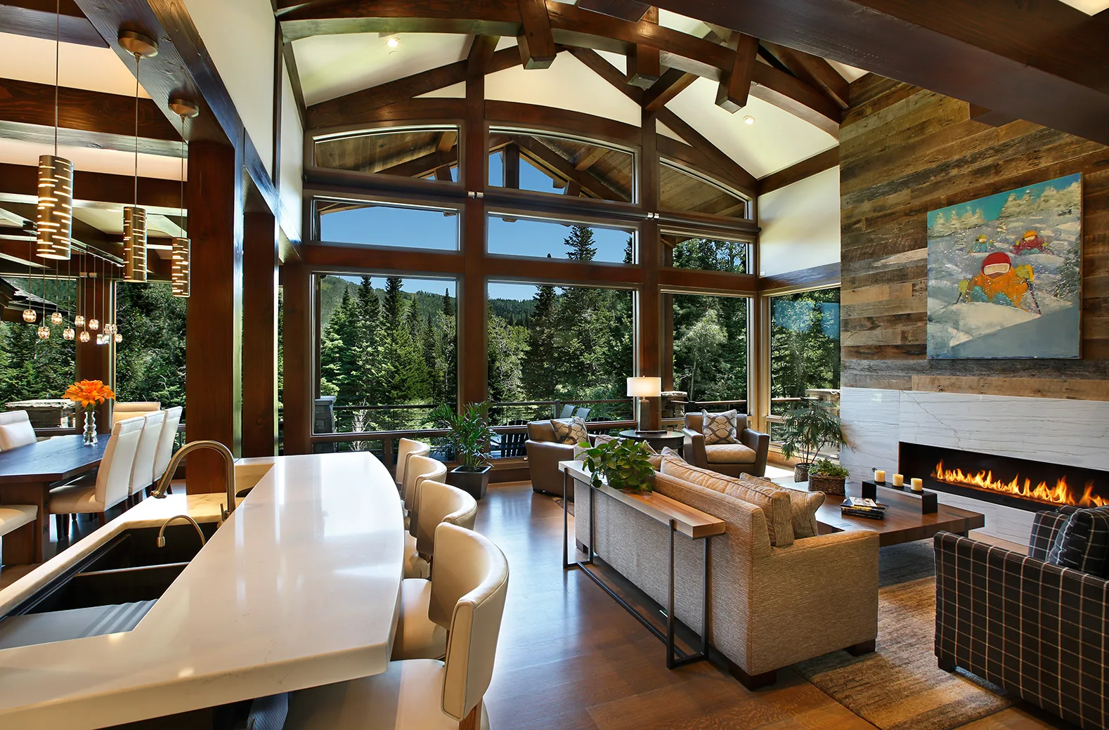 Kitchen with a white waterfall-edge island, cluster pendant lights and a vaulted timber ceiling with a glass wall