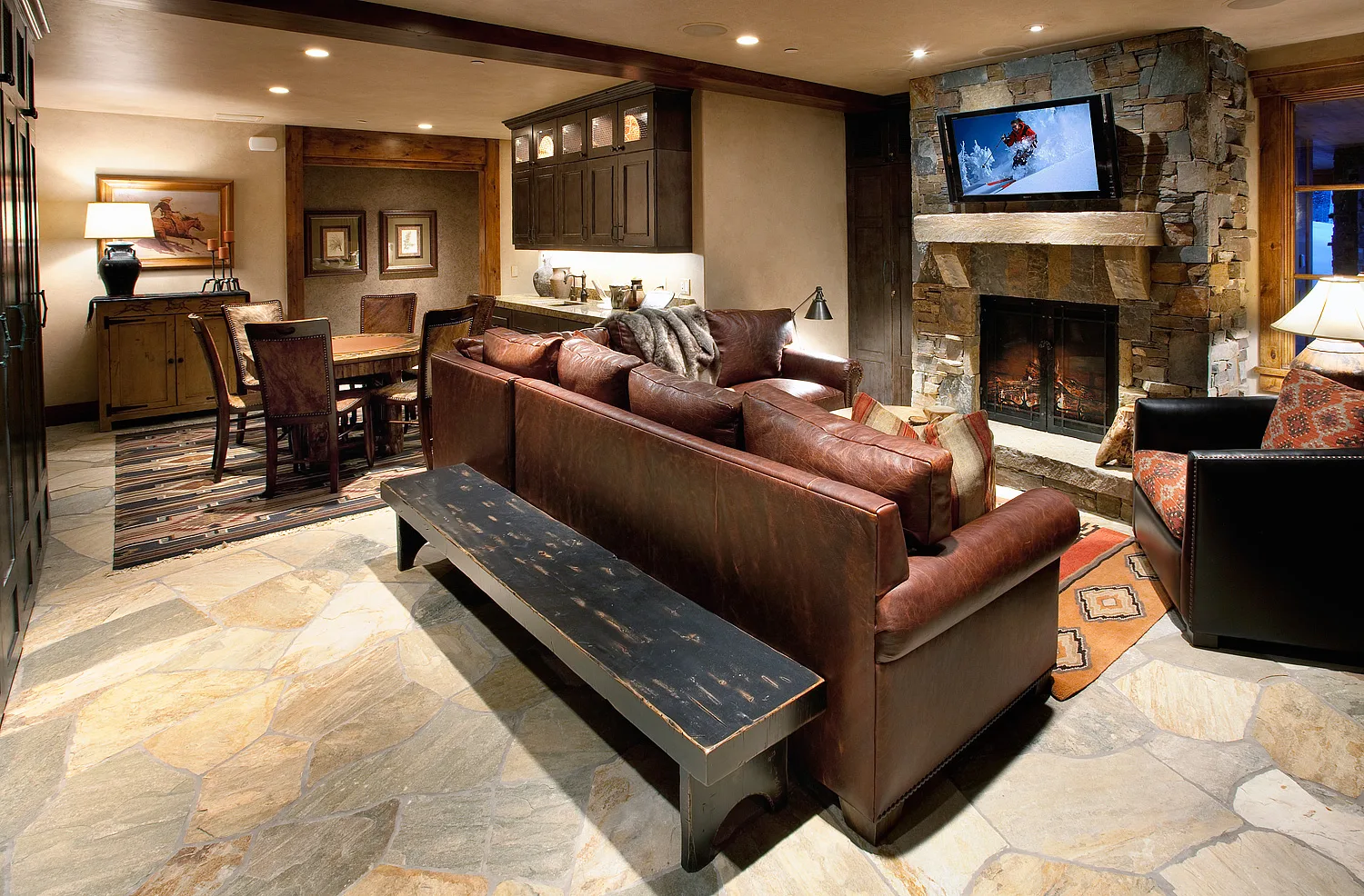 Dining area with a long wood table and bench seating against wood paneled walls