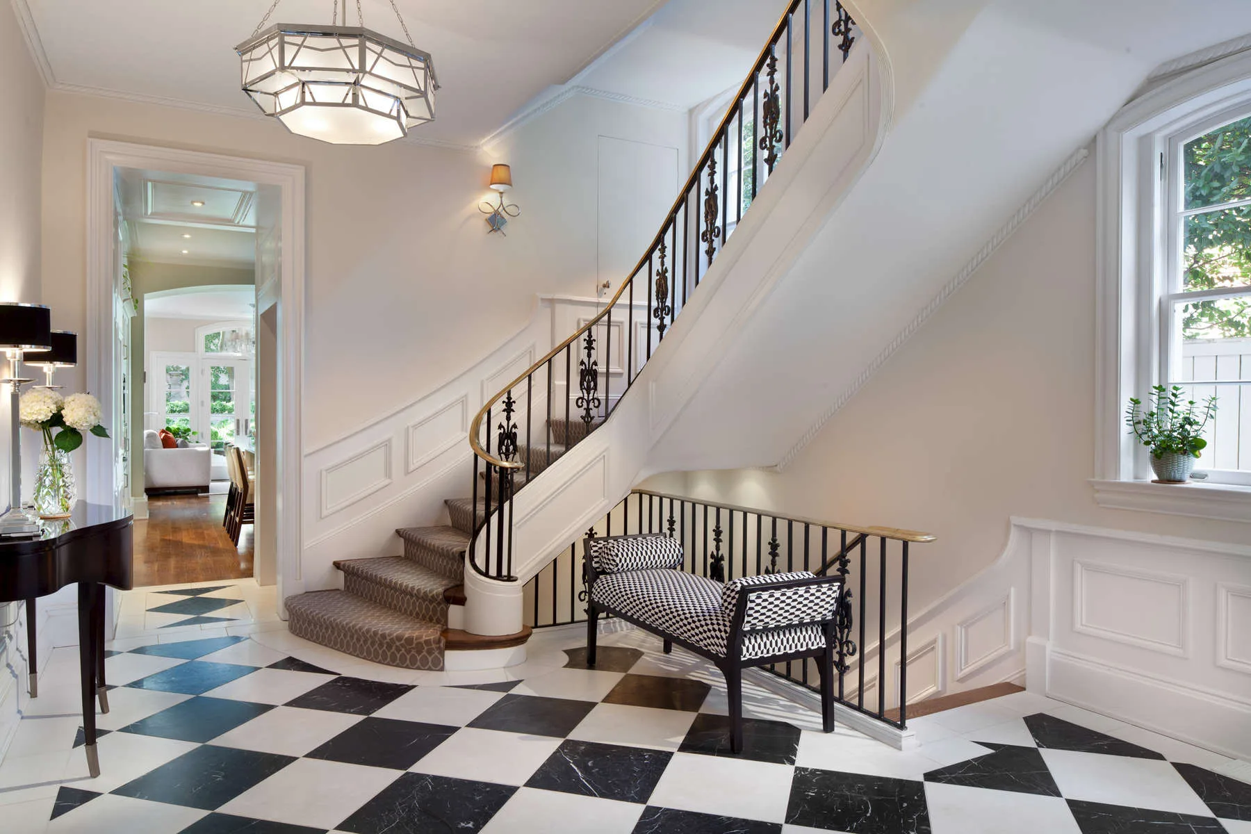 Foyer with a pendant light, archway and wood floors in a traditional city home