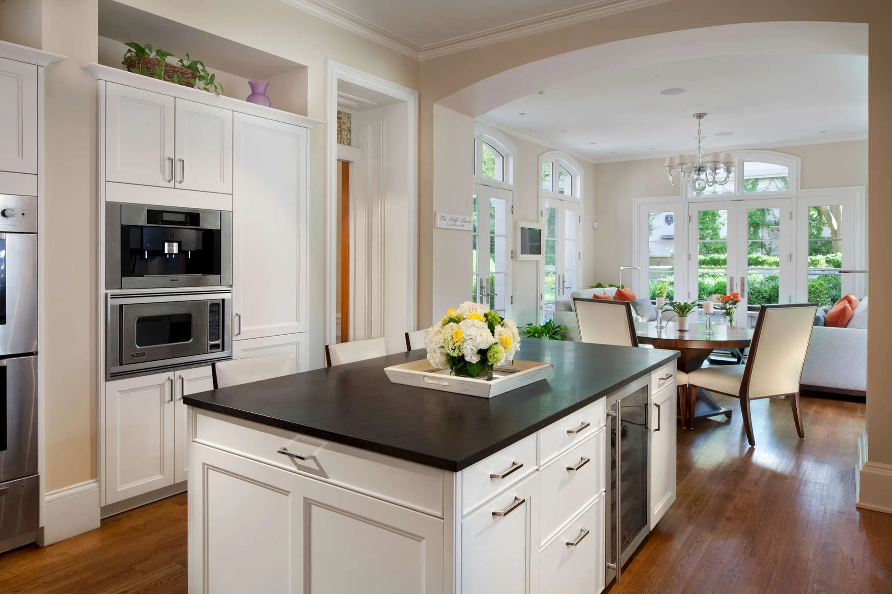 Kitchen breakfast nook with white cabinets and a round table set with flowers
