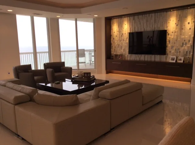Living area with a sectional sofa and windows