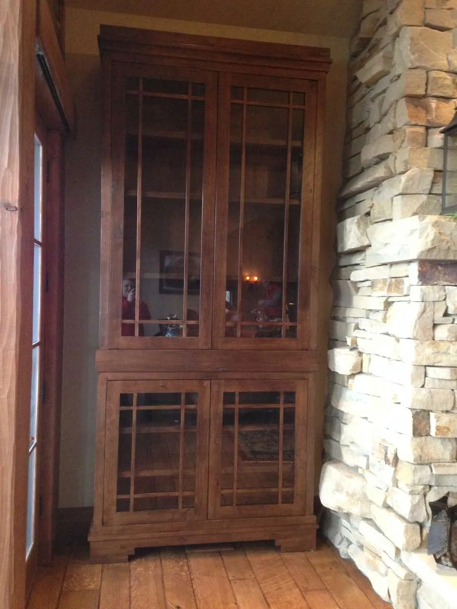 Custom bookcase with glass doors built into a stone accent wall