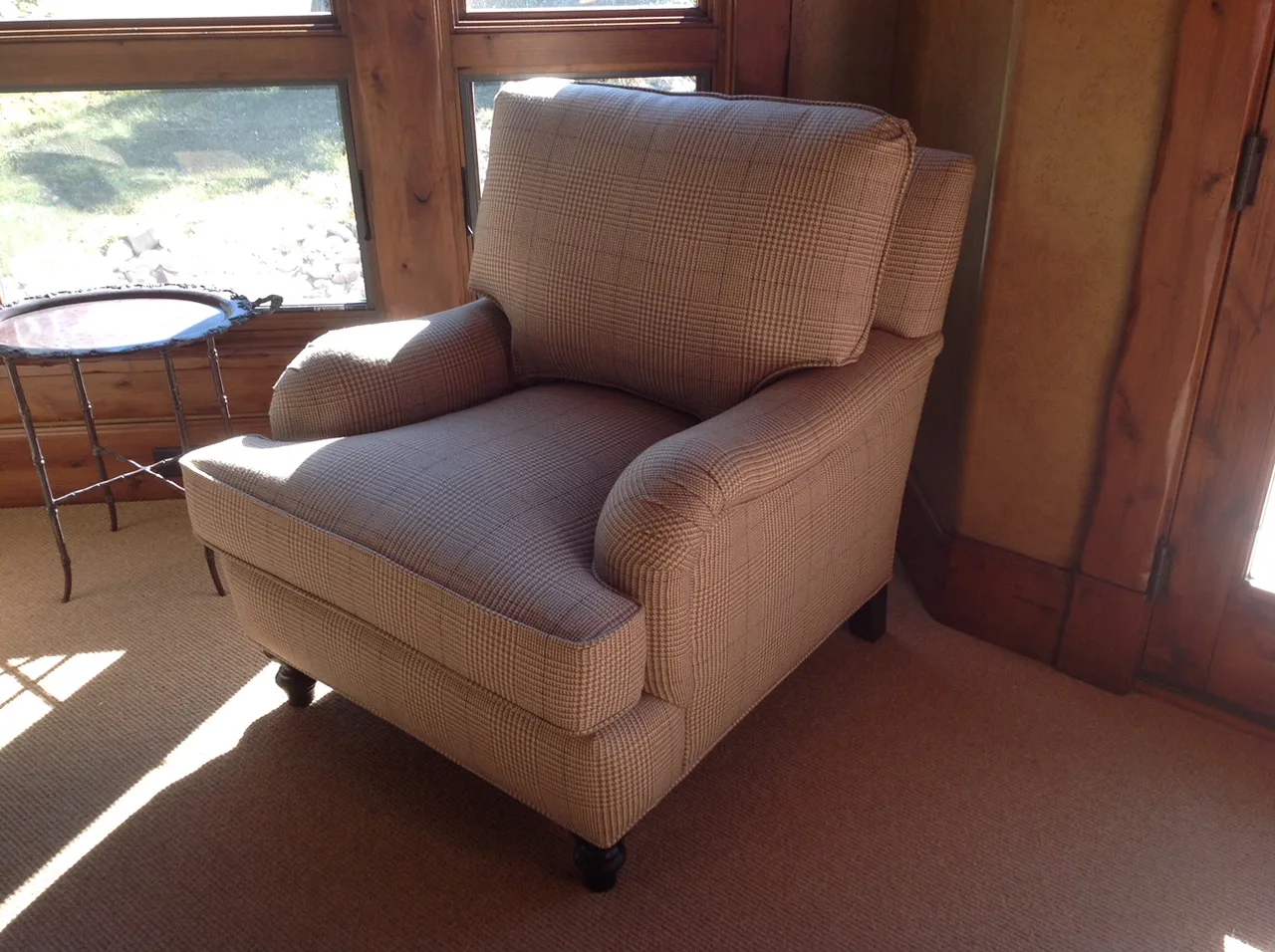 Sectional sofa with throw pillows beside a leather armchair