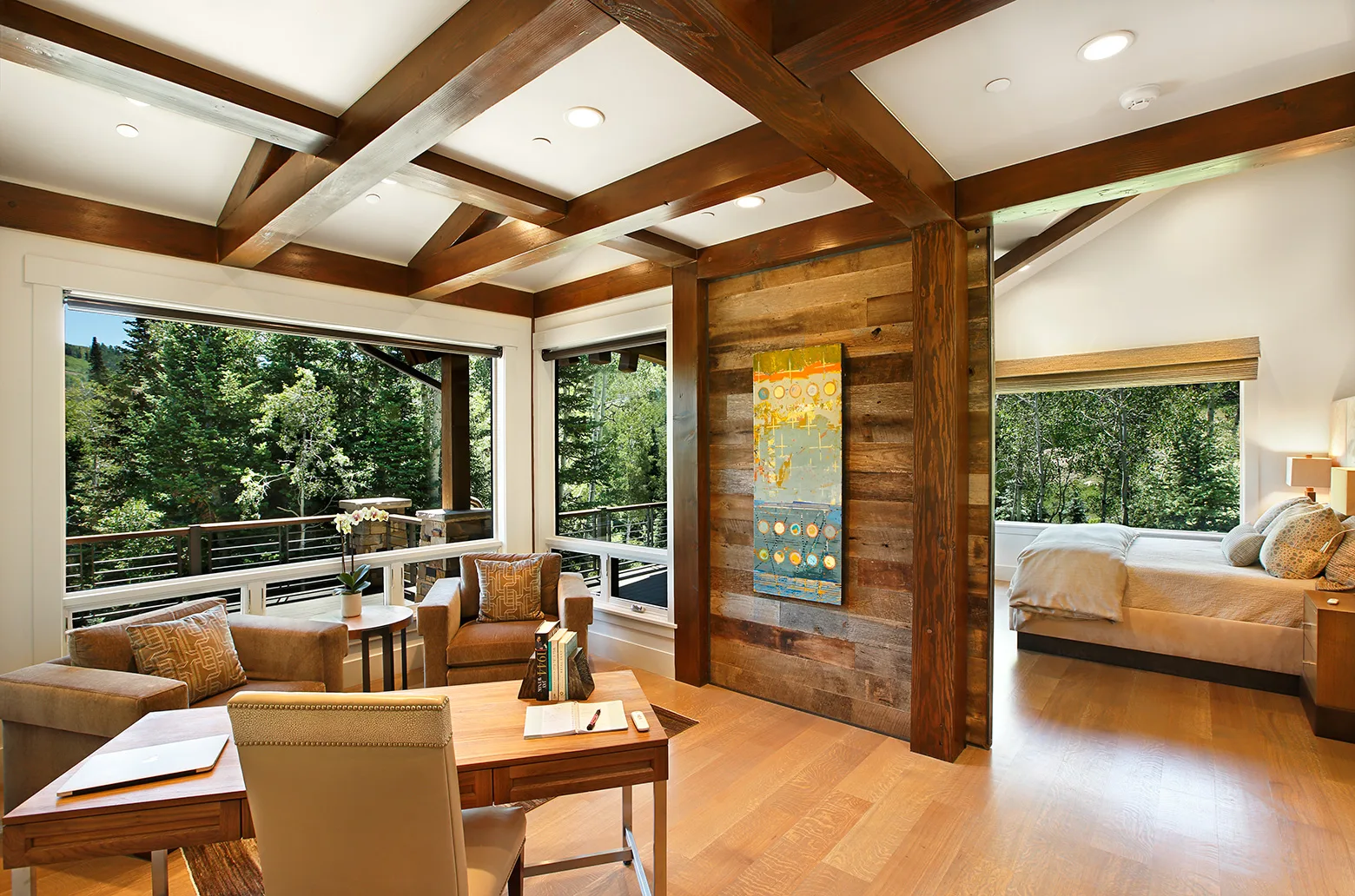 Living room with a coffered wood ceiling, large windows and neutral furniture