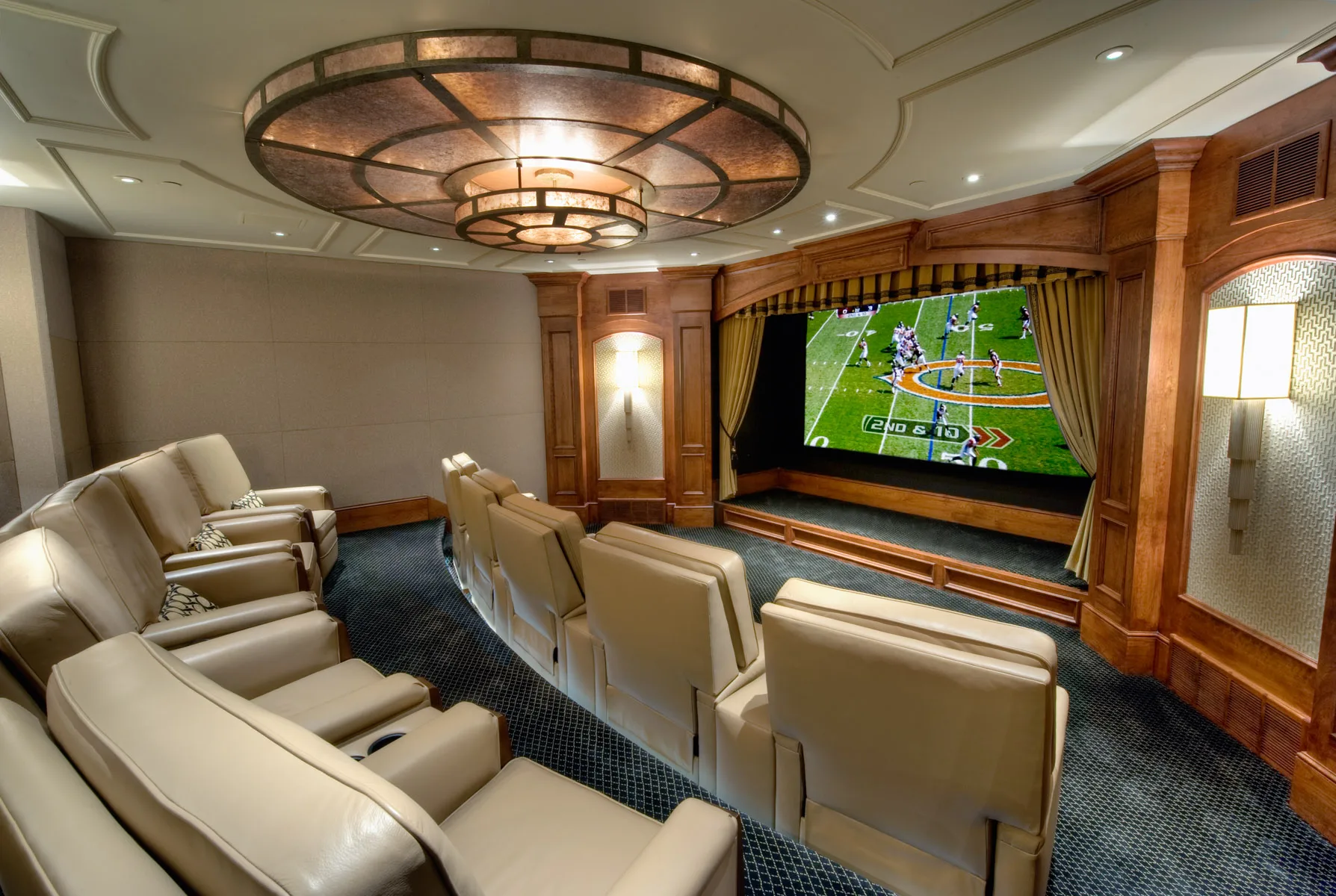 Home theater with a round tray ceiling light fixture, reclining leather seats and a projection screen