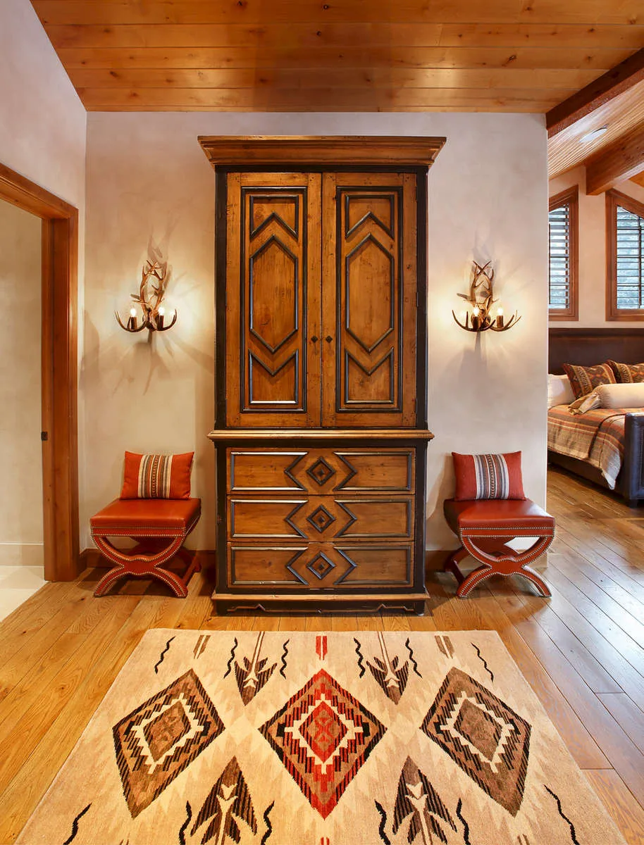 Entryway with a carved wood cabinet, a southwestern patterned rug and chairs