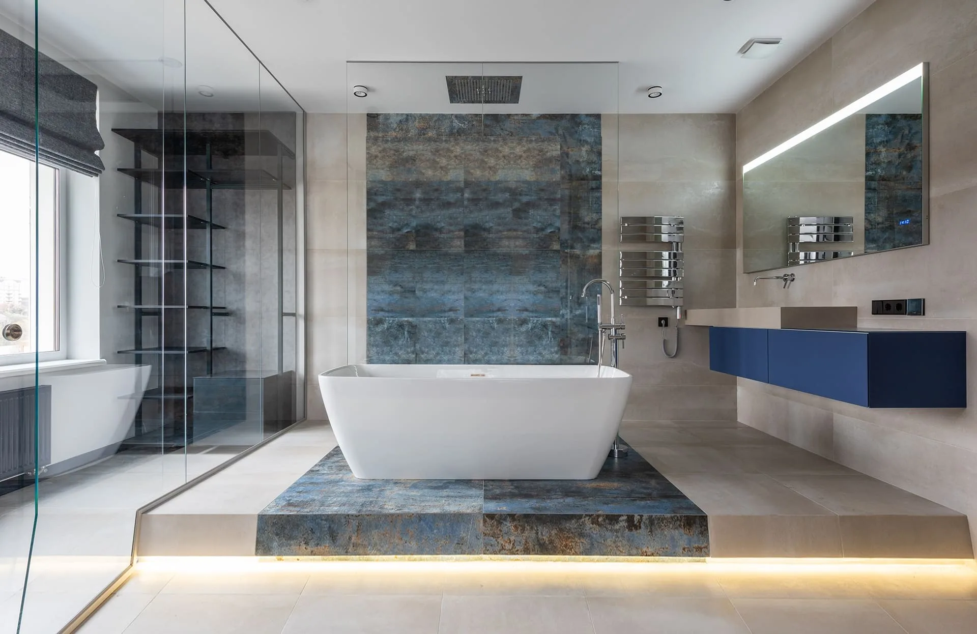 Bathroom with a freestanding tub and a blue tile wall