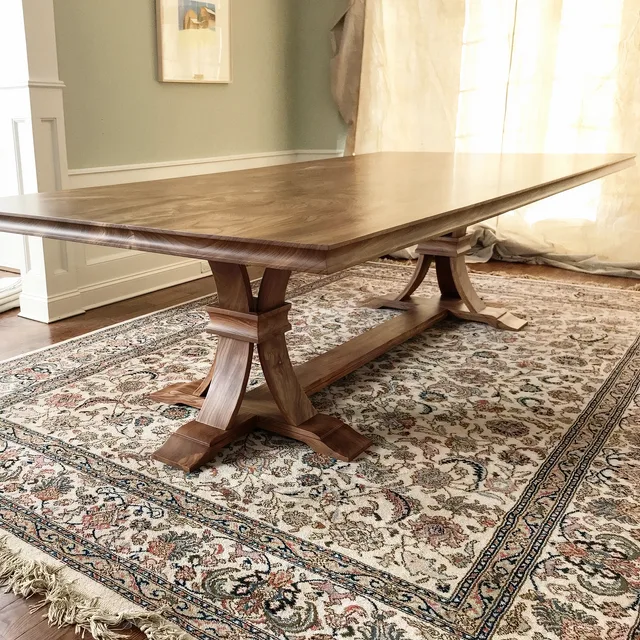 Custom Tables: walnut trestle dining table on rug, Custom Tables